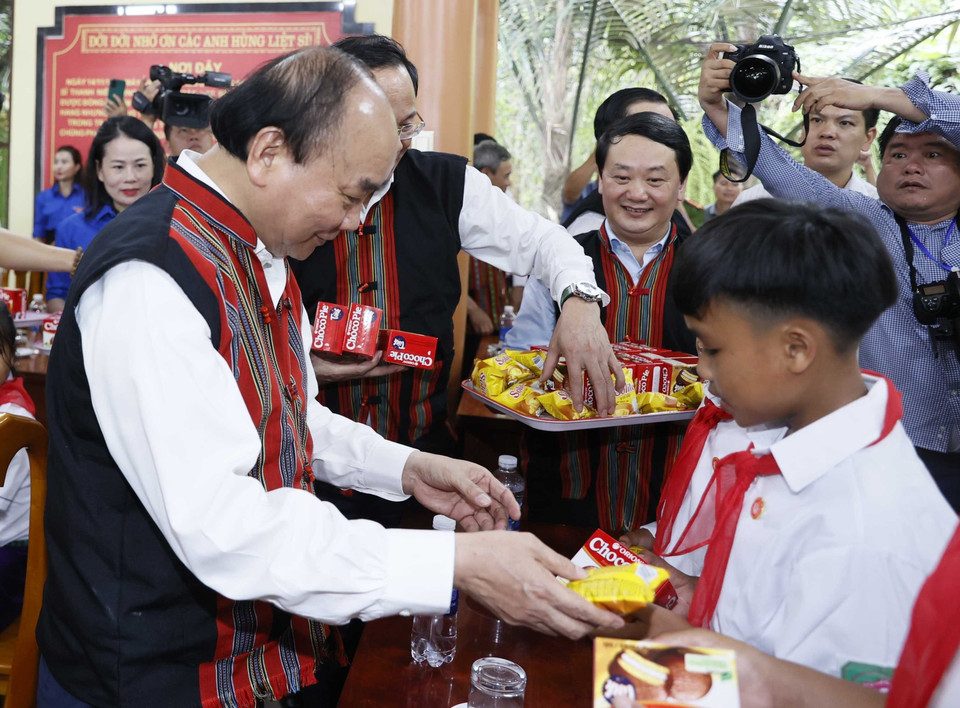 Chủ tịch nước Nguyễn Xuân Phúc tặng quà cho các em học sinh dân tộc thiểu số tại 2 xã Tân Trạch và Thượng Trạch. (Ảnh: Thống Nhất/TTXVN)