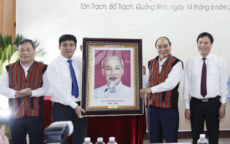 Chủ tịch nước Nguyễn Xuân Phúc tặng phẩm lưu niệm cho đại diện lãnh đạo huyện Bố Trạch, tỉnh Quảng Bình. (Ảnh: Thống Nhất/TTXVN)