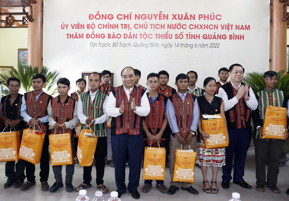 Chủ tịch nước Nguyễn Xuân Phúc tặng quà già làng, trưởng bản tại 2 xã Tân Trạch và Thượng Trạch. (Ảnh: Thống Nhất/TTXVN)