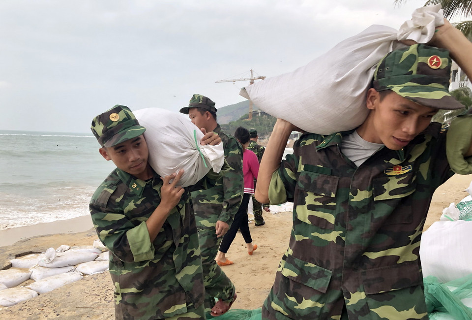  Lực lượng vũ trang tại tỉnh Bình Định vận chuyển bao tải cát giúp người dân xã Nhơn Hải, thành phố Quy Nhơn gia cố nhà cửa chống bão số 6. (Ảnh: Nguyên Linh/TTXVN)