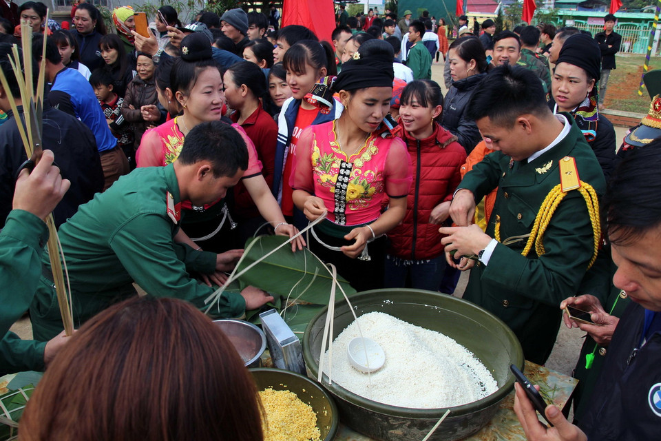  Các chiến sỹ và nhân dân các dân tộc tỉnh Sơn La gói bánh chưng tại chương trình Xuân biên cương, Tết quân dân. (Ảnh: Diệp Anh/TTXVN)