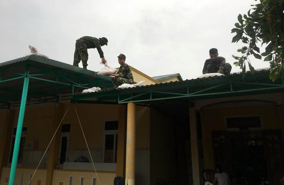  Bộ đội biên phòng Quảng Trị giúp người dân chằng chống nhà cửa chuẩn bị ứng phó với bão số 5. (Ảnh: Hồ Cầu/TTXVN)