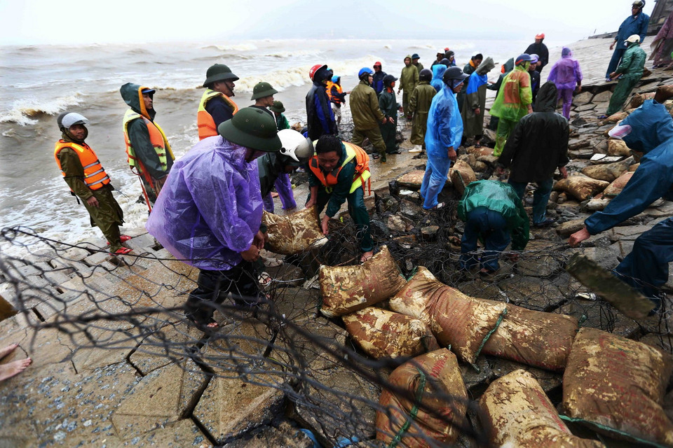  Lực lượng quân đội phối hợp với chính quyền và người dân xã Cẩm Nhượng, huyện Cẩm Xuyên, Hà Tĩnh khẩn trương khắc phục điểm sạt lở đê kè biển, khu vực nhiều hộ dân sống sát biển sau trận lũ lịch sử tháng 10 vừa qua. (Ảnh: TTXVN)