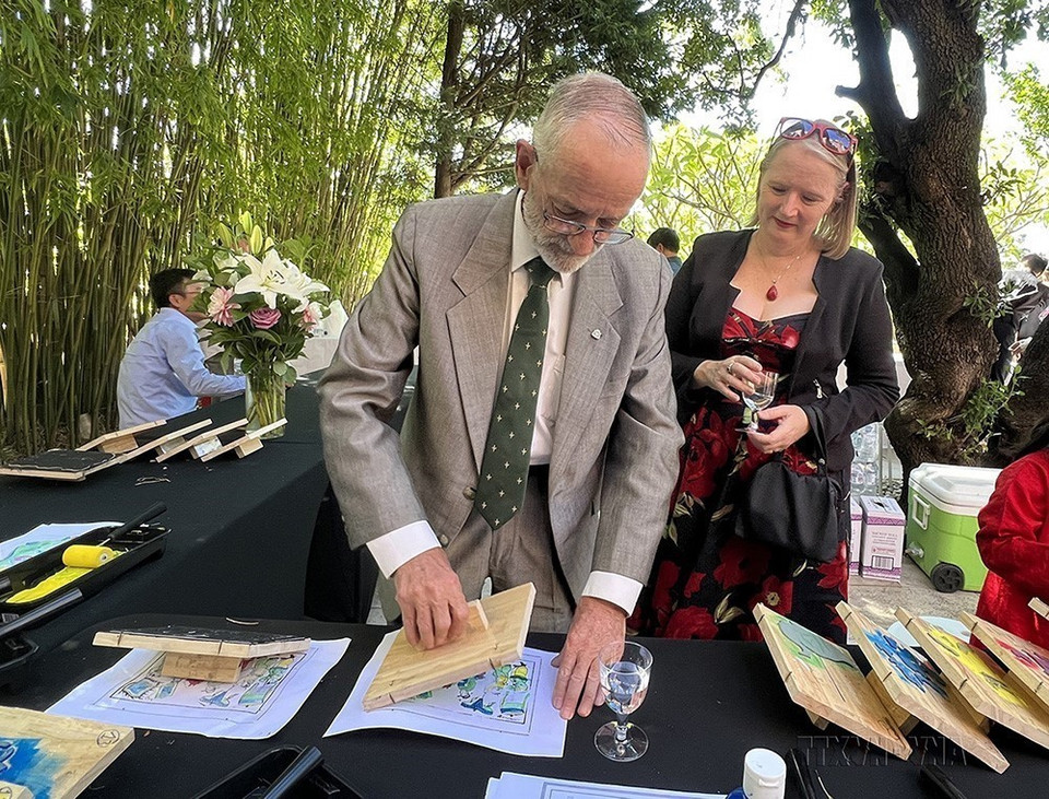 Bên cạnh quan hệ về kinh tế, Việt Nam và Australia đang ngày càng gắn kết về xã hội và văn hóa. Trong ảnh: Đại biểu Australia hứng thú in tranh dân gian Đông Hồ khi tham dự buổi gặp mặt mừng Xuân Quý Mão 2023 tại Tổng lãnh sự quán Việt Nam ở thành phố Sydney, Australia (4/2/2023). (Ảnh: Văn Đạt/TTXVN)