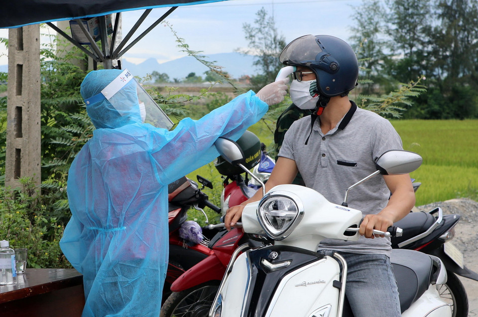 Đo thân nhiệt người tham gia lưu thông tại các vùng có dịch. (Ảnh: Trần Lê Lâm/TTXVN)