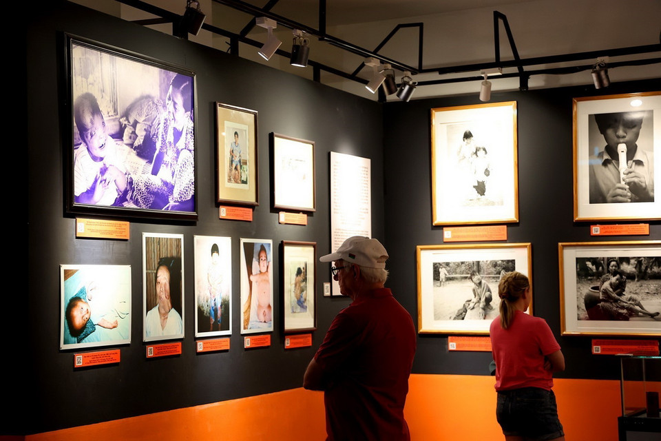  Khách quốc tế xem những hình ảnh về nạn nhân chất độc da cam Việt Nam trong Bảo tàng Chứng tích Chiến tranh. (Ảnh: Hồng Đạt/TTXVN)