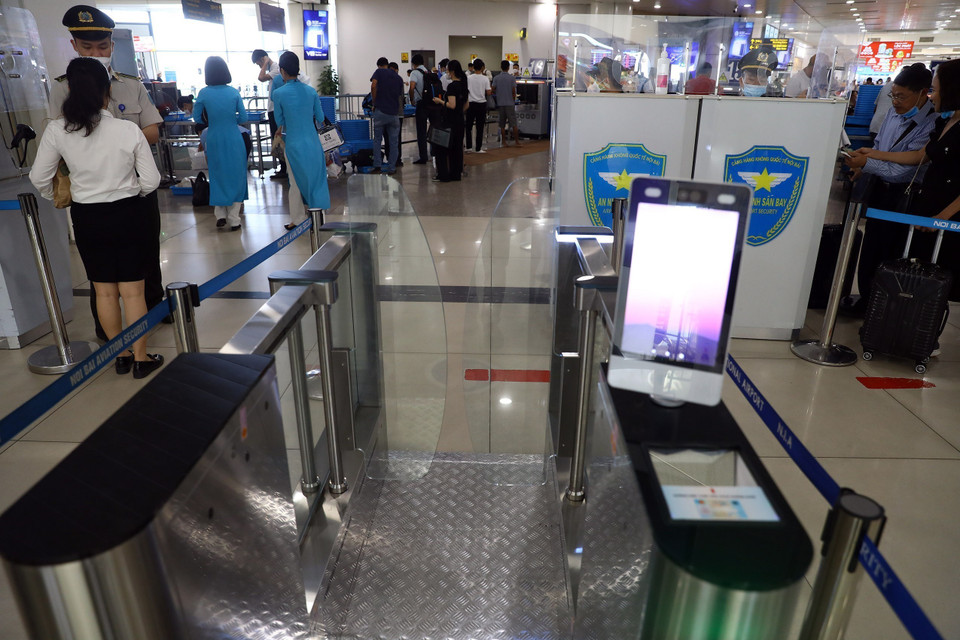 Khu vực cửa tự động an ninh điểm soi chiếu, hành khách chỉ cần đặt căn cước công dân vào khu vực thiết bị đọc, hệ thống sẽ nhận diện giúp hành khách đi qua được nhanh chóng. (Ảnh: Huy Hùng/TTXVN)