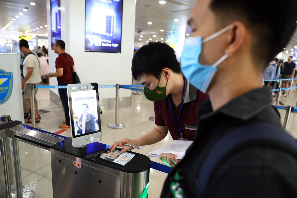 Khi hành khách khi đi qua cửa an ninh sẽ đặt căn cước công dân gắn chip vào máy quét đồng thời hướng mặt về phía camera chuyên dụng. (Ảnh: Huy Hùng/TTXVN)