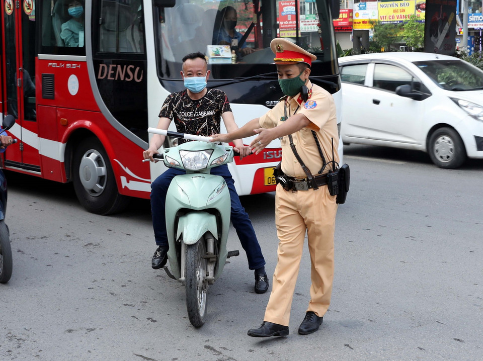  Cán bộ Đội CSGT số 7 kiểm tra và xử lý các trường hợp không đội mũ bảo hiểm khi tham gia giao thông tại ngã tư Khuất Duy Tiến-Nguyễn Trãi. (Ảnh: Phạm Kiên/TTXVN)