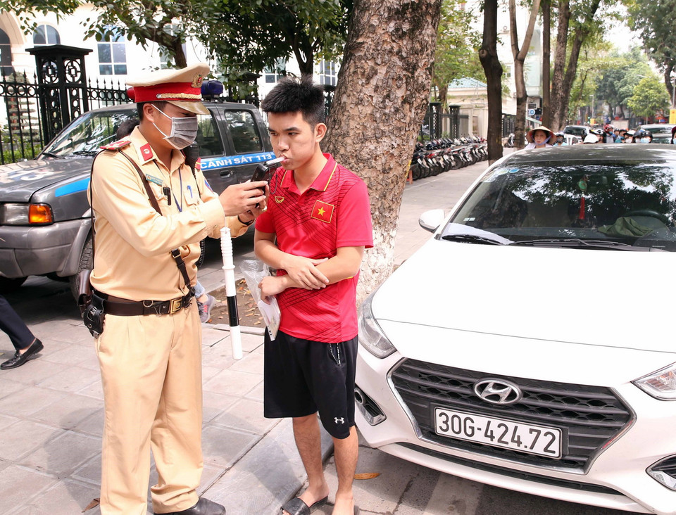  Cán bộ Đội CSGT số 4 kiểm tra nồng độ cồn với các tài xế ôtô tham gia giao thông tại chốt kiểm tra nồng độ cồn ngã tư Nguyễn Công Trứ-Lò Đúc. (Ảnh: Phạm Kiên/TTXVN)