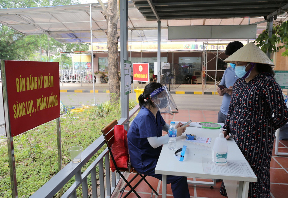 Khai báo y tế trước khi vào bệnh viện Thanh Nhàn. (Ảnh: Hoàng Hiếu/TTXVN)
