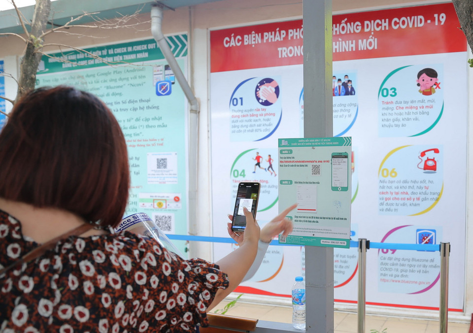  Người dân khai báo bằng QR code trước khi vào bệnh viện Thanh Nhàn. (Ảnh: Hoàng Hiếu/TTXVN)
