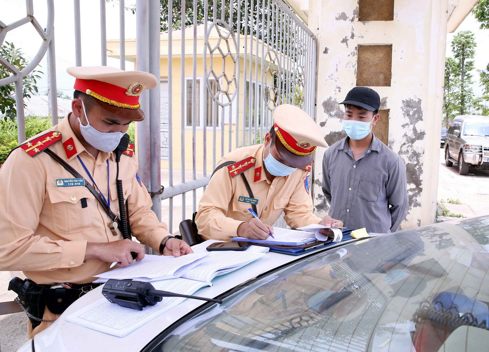  Đội CSGT số 10 lập biên bản xử lý với các chủ phương tiện tham gia giao thông quá tải trọng tại Quốc lộ 21B, huyện Thanh Oai, Hà Đông, Hà Nội. (Ảnh: Phạm Kiên/TTXVN)