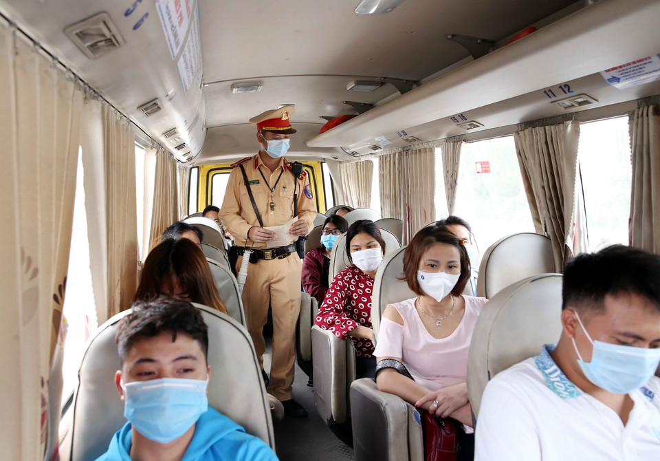  Cán bộ Đội CSGT số 8 kiểm tra số người quy định trên xe khách cũng như nhắc nhở người dân đeo khẩu trang đúng quy định trước tình hình dịch COVID-19 đang diễn biến phức tạp. (Ảnh: Phạm Kiên/TTXVN)