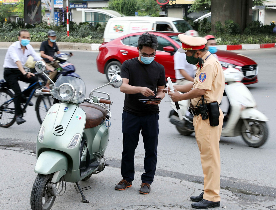  Cán bộ Đội CSGT số 7 kiểm tra và xử lý các trường hợp không đội mũ bảo hiểm khi tham gia giao thông tại ngã tư Khuất Duy Tiến-Nguyễn Trãi. (Ảnh: Phạm Kiên/TTXVN)