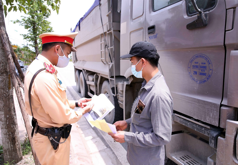  Cán bộ Đội CSGT số 10 kiểm tra và xử lý với các chủ phương tiện tham gia giao thông quá tải trọng tại Quốc lộ 21B, huyện Thanh Oai, Hà Đông, Hà Nội. (Ảnh: Phạm Kiên/TTXVN)