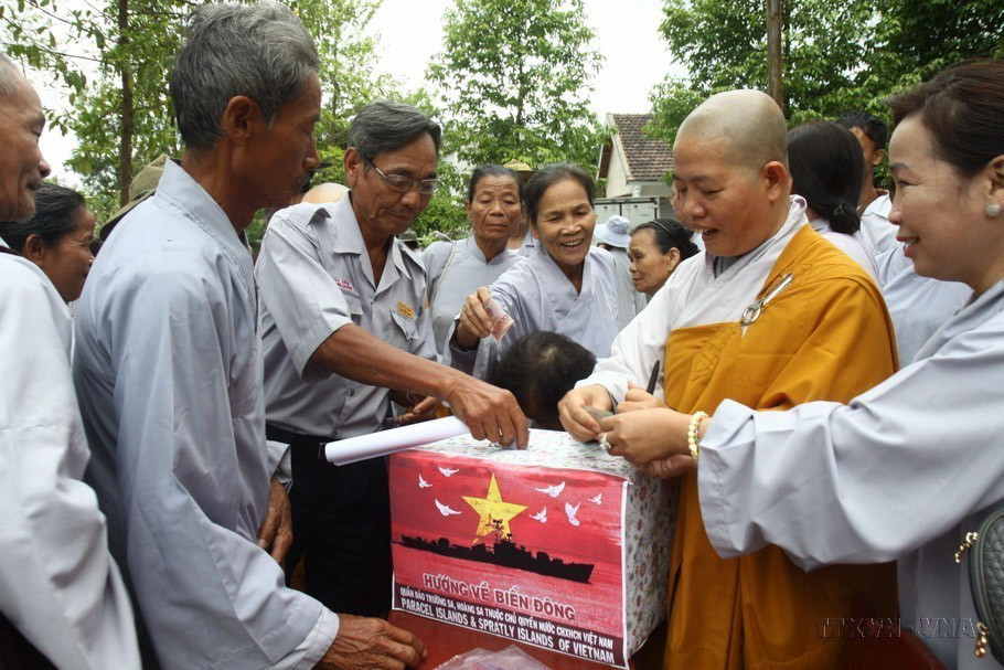Các phật tử đóng góp ủng hộ Chương trình "Nghĩa tình Hoàng Sa-Trường Sa" tại Lễ cầu nguyện hòa bình cho Biển Đông, năm 2014. (Ảnh: Hồ Cầu/TTXVN)