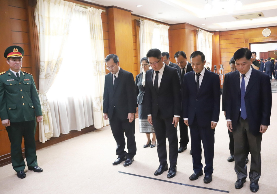 Phó Trưởng ban Đối ngoại Trung ương Đảng Nhân dân Cách mạng Lào Valaxay Lengsavath và đoàn dành phút mặc niệm tưởng nhớ Tổng Bí thư Nguyễn Phú Trọng. (Ảnh: Xuân Tú/TTXVN)