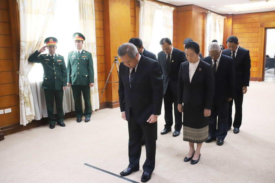 Bộ trưởng Bộ Công nghệ và truyền thông Lào kiêm Chủ tịch Trung ương Hội Hữu nghị Lào-Việt Nam Boviengkham Vongdara và đoàn dành phút mặc niệm tưởng nhớ Tổng Bí thư Nguyễn Phú Trọng. (Ảnh: Xuân Tú/TTXVN)
