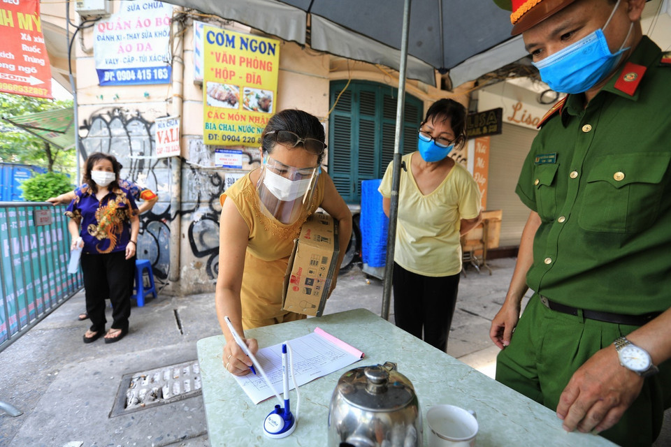 Tại chốt Vùng xanh ngõ Hà Trung, phường Hàng Bông, người dân vui vẻ chấp hành khai báo y tế, thực hiện nghiêm nguyên tắc 5K. (Ảnh: Thành Đạt/TTXVN)