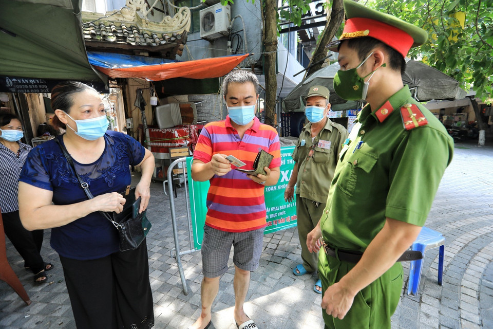 Lực lượng công an tại chốt Vùng xanh tổ dân phố số 3, phố Tống Duy Tân, phường Hàng Bông kiểm tra giấy tờ tùy thân của người dân mỗi khi ra vào. (Ảnh: Thành Đạt/TTXVN)