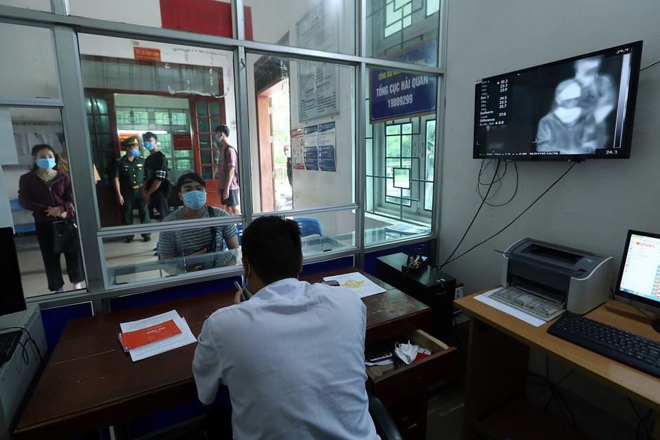 Đo thân nhiệt của công dân trước khi làm thủ tục nhập cảnh tại Cửa khẩu Quốc tế Tây Trang. (Ảnh: Phan Tuấn Anh/TTXVN)