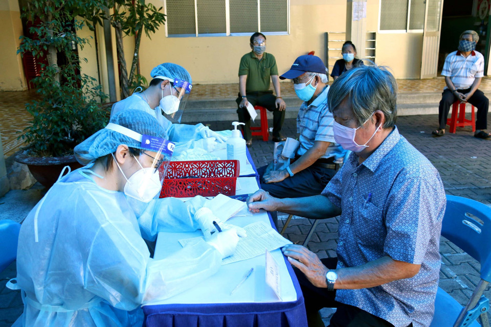 Các y bác sỹ Quận 3 tư vấn, kiểm tra sức khỏe cho người trên 65 tuổi trước khi tiêm vaccine phòng COVID-19 tại điểm tiêm trường tiểu học Trần Quốc Thảo. (Ảnh: Thanh Vũ/TTXVN)