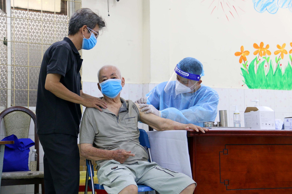 Các y bác sỹ Quận 3 tiêm vaccine phòng COVID-19 cho người trên 65 tuổi, có bệnh nền tại điểm tiêm trường tiểu học Trần Quốc Thảo. (Ảnh: Thanh Vũ/TTXVN)