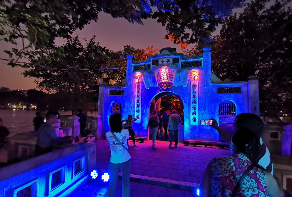 Khu vực tháp Bút và cầu Thê Húc, những biểu tượng của Hà Nội được thắp sáng với màu xanh thể hiện hy vọng cũng như cơ hội cho trẻ em và cho tất cả mọi người. (Ảnh: Thành Đạt/TTXVN)