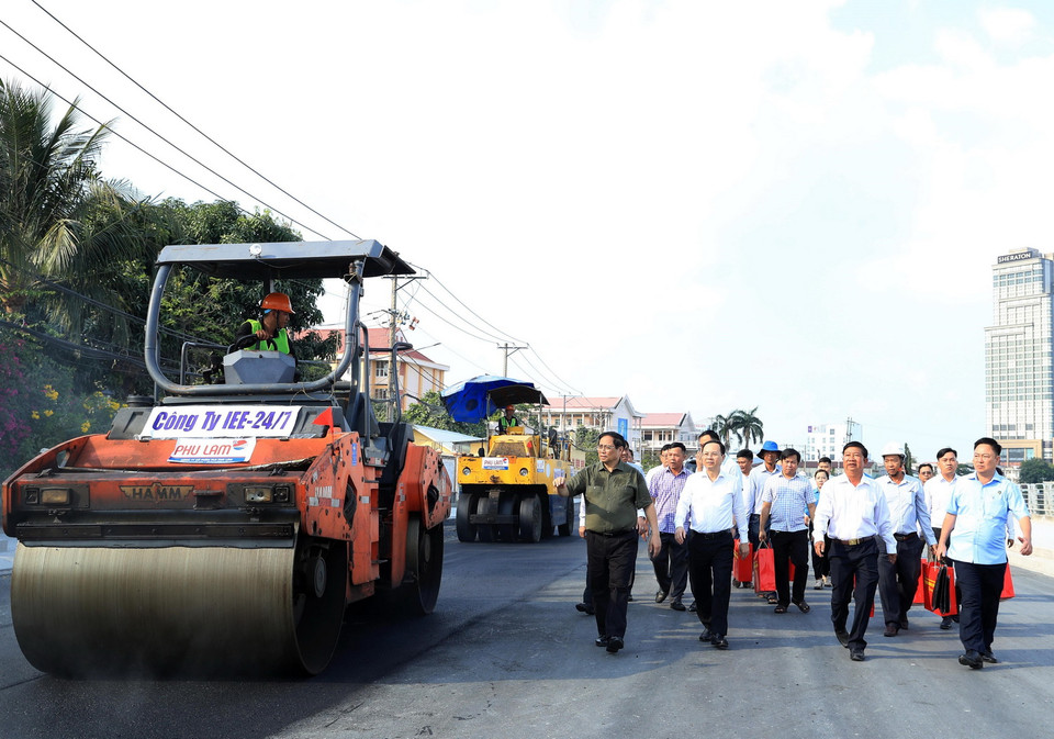 Thủ tướng Phạm Minh Chính tặng quà, động viên công nhân đang thi công tuyến đê kè ứng phó biến đổi khí hậu tại sông Cần Thơ thuộc Dự án phát triển thành phố Cần Thơ. (Ảnh: Văn Điệp/TTXVN)