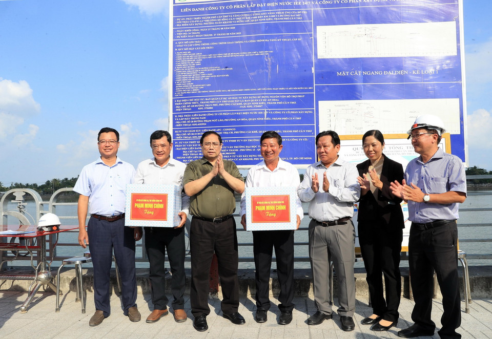 Thủ tướng Phạm Minh Chính tặng quà chủ đầu tư, Ban quản lý, nhà thầu đang thi công tuyến đê kè ứng phó biến đổi khí hậu tại sông Cần Thơ thuộc Dự án phát triển thành phố Cần Thơ. (Ảnh: Văn Điệp/TTXVN)