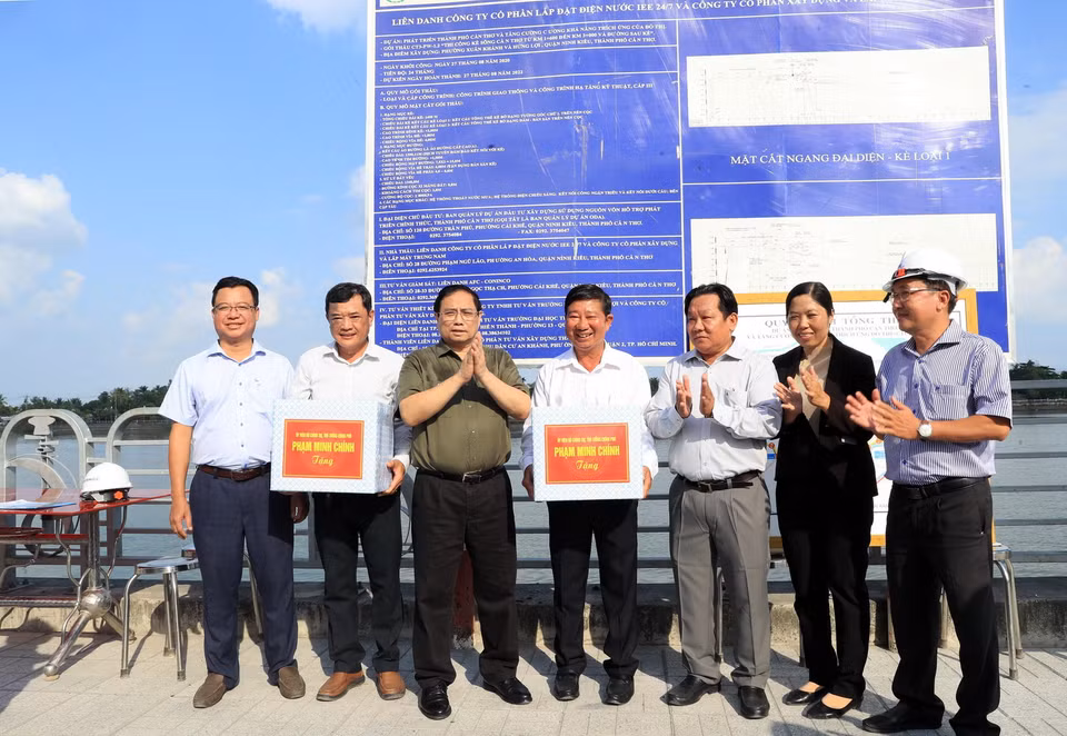Thủ tướng Phạm Minh Chính tặng quà chủ đầu tư, Ban quản lý, nhà thầu đang thi công tuyến đê kè ứng phó biến đổi khí hậu tại sông Cần Thơ thuộc Dự án phát triển thành phố Cần Thơ. (Ảnh: Văn Điệp/TTXVN)