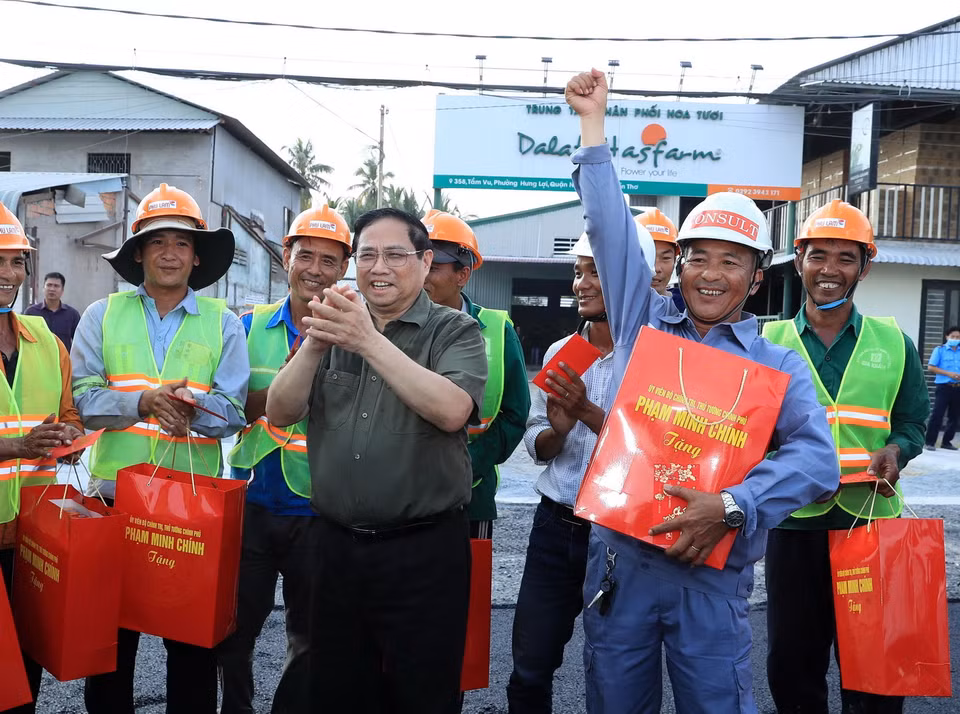 Thủ tướng Phạm Minh Chính tặng quà, động viên công nhân đang thi công tuyến đê kè ứng phó biến đổi khí hậu tại sông Cần Thơ thuộc Dự án phát triển thành phố Cần Thơ. (Ảnh: Văn Điệp/TTXVN)