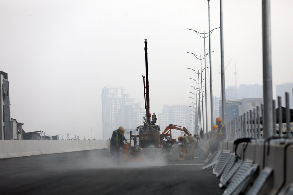 Công nhân đang tiến hành hoàn thiện các hạng mục lắp dải phân cách. (Ảnh: Huy Hùng/TTXVN)