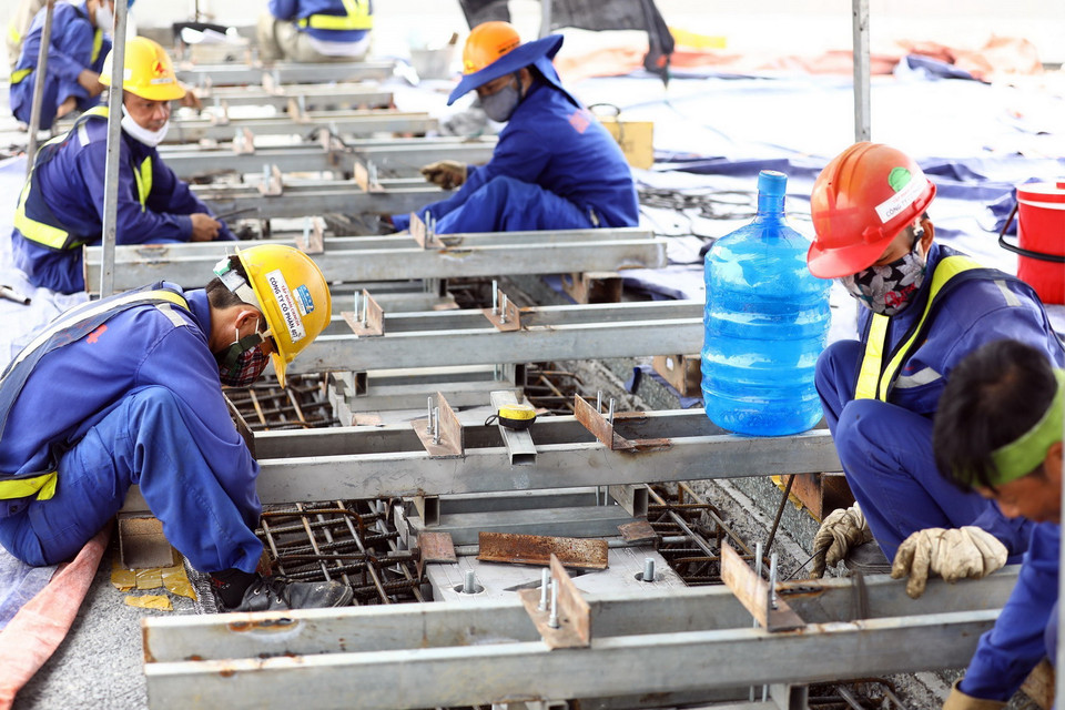 Công nhân đang thi công khe co giãn trên tuyến đường. (Ảnh: Huy Hùng/TTXVN)