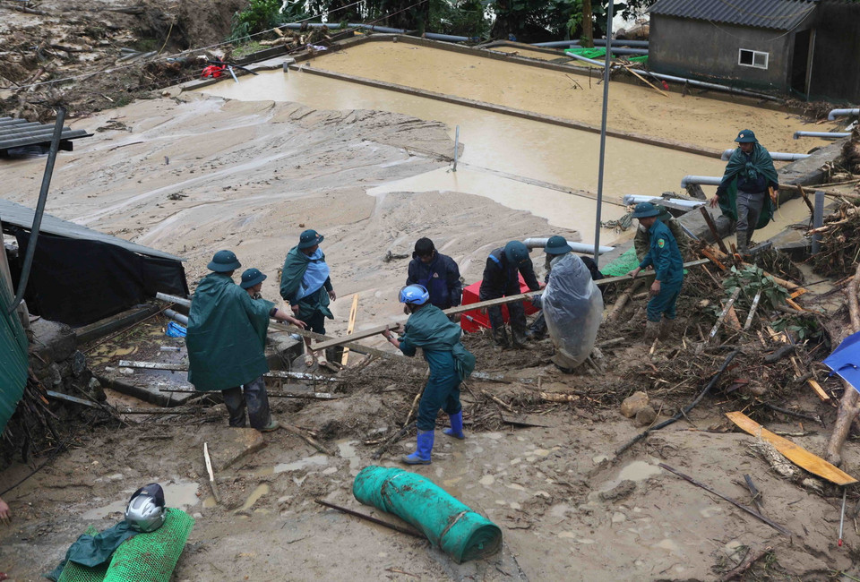 Các lực lượng chức năng của huyện Tam Đường khắc phục hậu quả do cơn Lũ dự đi qua tại trang trại nuôi cá nước lạnh của gia đình nhà ông Dương Ngọc Hưng tại bản Chu Va 12, xã Sơn Bình, huyện Tam Đường. (Ảnh: Quý Trung/TTXVN)