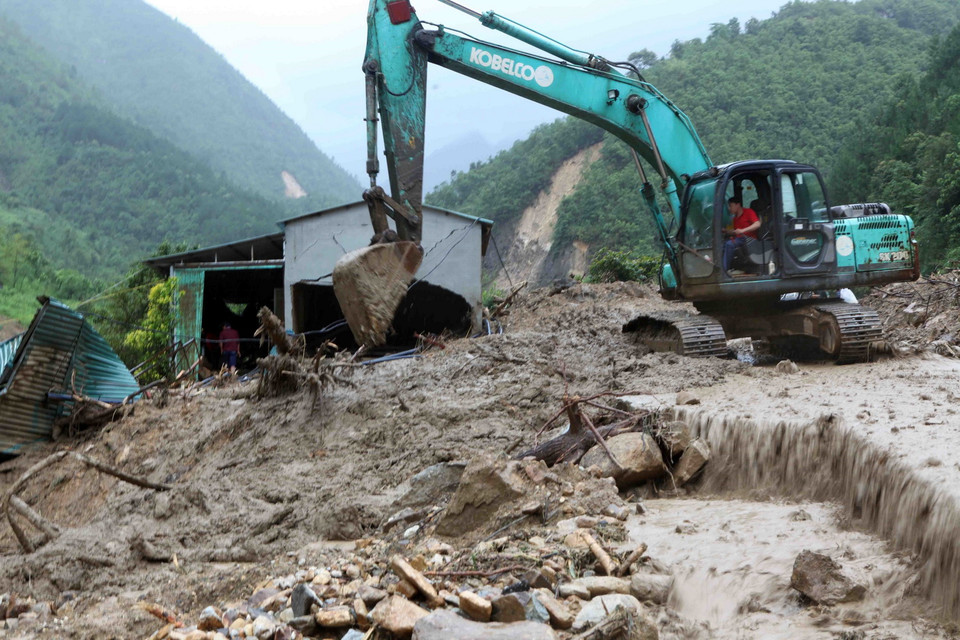 Các lực lượng chức năng đang khẩn trương khắc phục đoạn đường Quốc lộ 4D tại Km 73 do lượng đất đá vùi lấp khiến tuyến đường tiếp tục bị tê liệt. (Ảnh: Quý Trung/TTXVN)