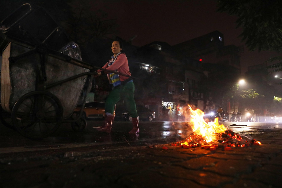 Một nhân viên vệ sinh môi trường đi thu gom rác trên phố Huế. (Ảnh: Lâm Khánh/TTXVN)