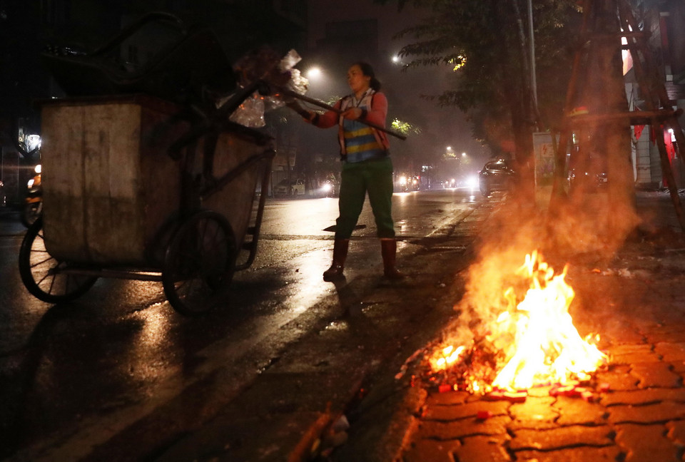 Một nhân viên vệ sinh môi trường đi thu gom rác trên phố Huế. (Ảnh: Lâm Khánh/TTXVN)