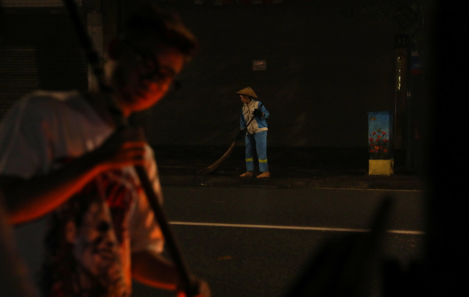 Một nhân viên vệ sinh môi trường quét, thu gom rác trên phố Huế, quận Hai Bà Trưng. (Ảnh: Lâm Khánh/TTXVN)