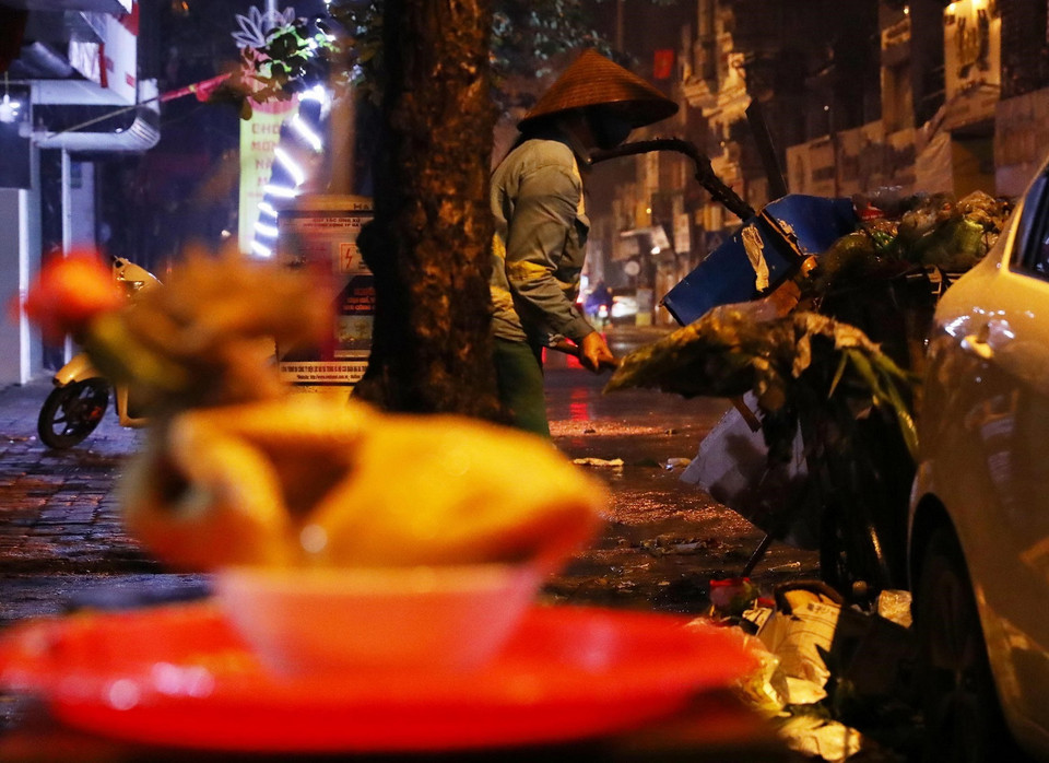 Một nhân viên vệ sinh môi trường thu gom rác thải trên phố Bạch Mai, quận Hai Bà Trưng. (Ảnh: Lâm Khánh/TTXVN)