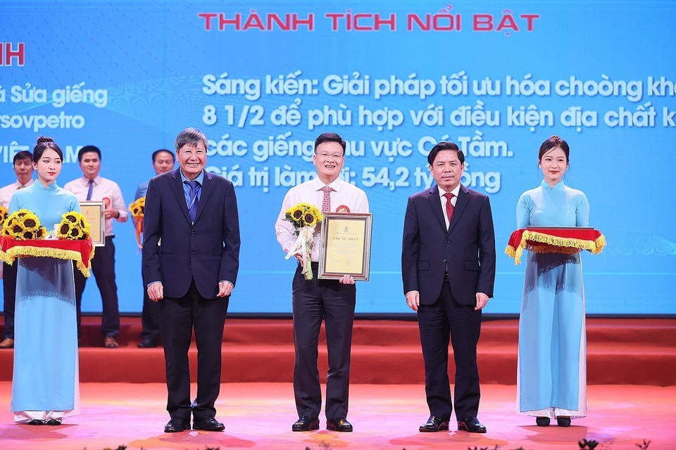 Thủ tướng Phạm Minh Chính và Chủ tịch Tổng Liên đoàn Lao động Việt Nam Nguyễn Đình Khang trao chứng nhận và hoa vinh danh các tác giả, nhóm tác giả có thành tích đặc biệt xuất sắc. (Ảnh: Dương Giang/TTXVN)