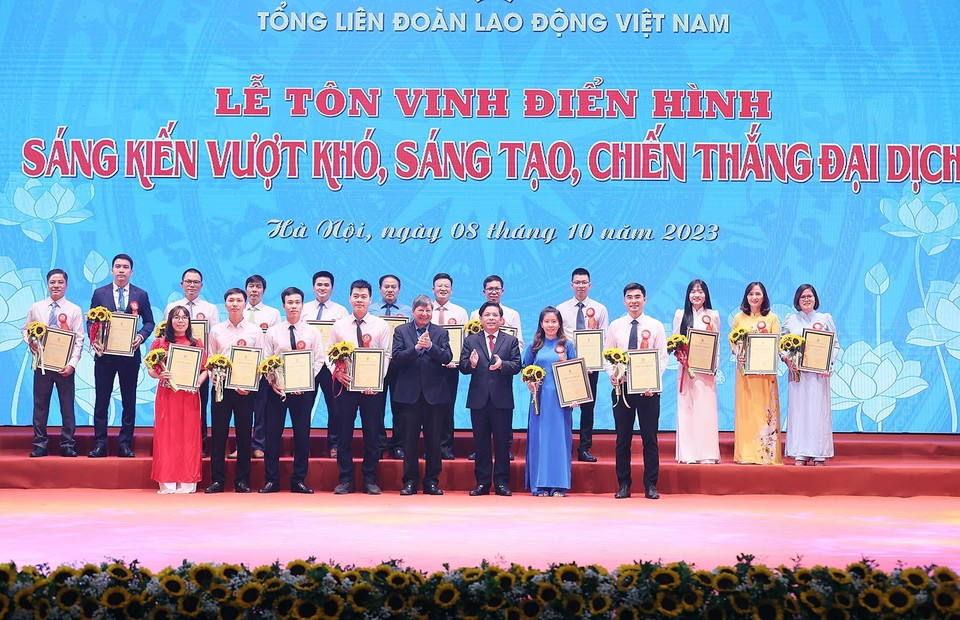 Bí thư Đảng ủy khối các Cơ quan Trung ương Nguyễn Văn Thể và Phó Chủ tịch thường trực Tổng Liên đoàn Lao động Việt Nam Trần Thanh Hải trao chứng nhận và hoa vinh danh các tác giả, nhóm tác giả có thành tích xuất sắc. (Ảnh: Dương Giang/TTXVN)