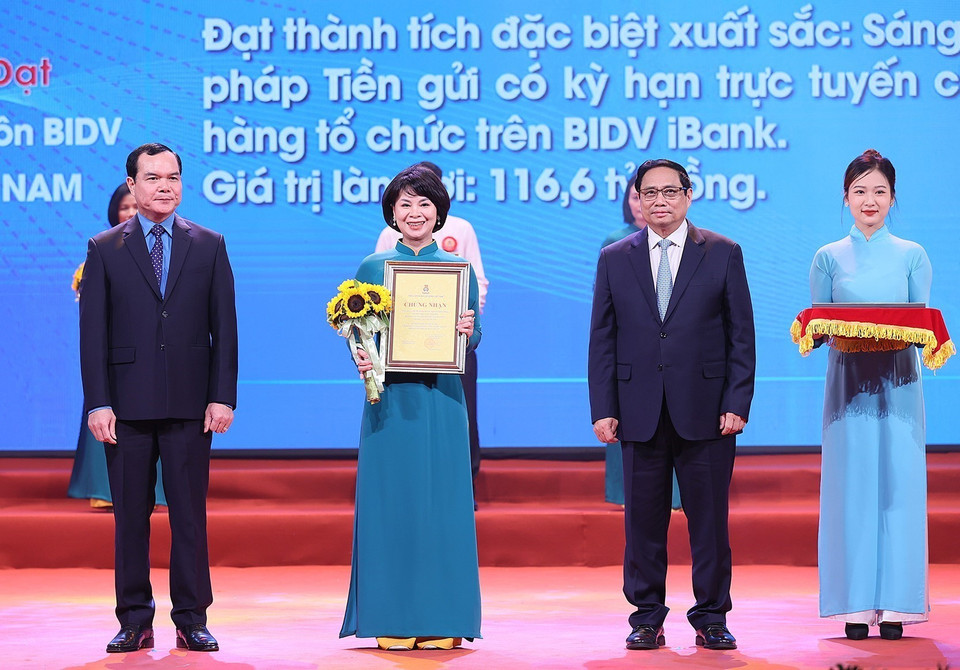 Thủ tướng Phạm Minh Chính và Chủ tịch Tổng Liên đoàn Lao động Việt Nam Nguyễn Đình Khang trao chứng nhận và hoa vinh danh các tác giả, nhóm tác giả có thành tích đặc biệt xuất sắc. (Ảnh: Dương Giang/TTXVN)