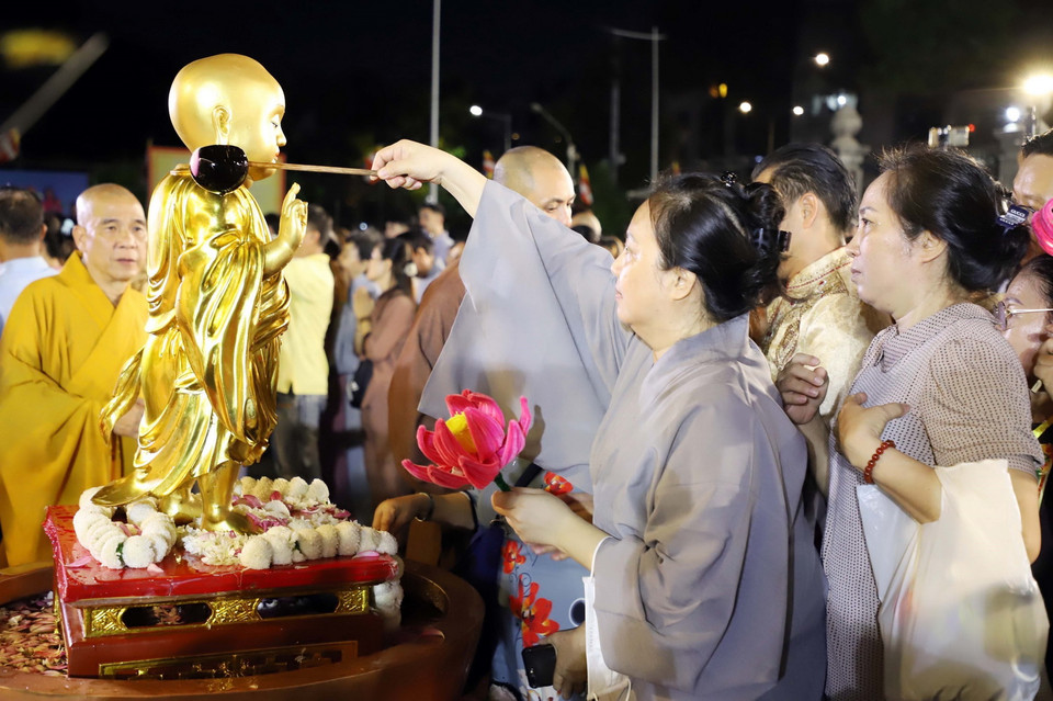 Phật tử, người dân yêu đạo Phật tại Thành phố Hồ Chí Minh thành kính thực hiện nghi lễ Tắm Phật tại Việt Nam Quốc tự. (Ảnh: Xuân Khu/TTXVN)