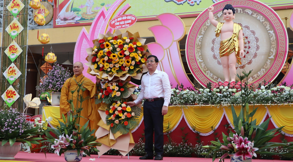 Phó Bí thư Thường trực Tỉnh ủy, Chủ tịch HĐND tỉnh Hậu Giang Trần Văn Huyến tặng hoa chúc mừng đại lễ Phật đản. (Ảnh: Hồng Thái/TTXVN)