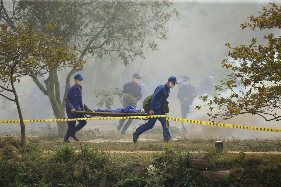 Lực lượng dân quân khẩn trương đưa người bị nạn ra khỏi khu vực nguy hiểm. (Ảnh: Dương Giang/TTXVN)