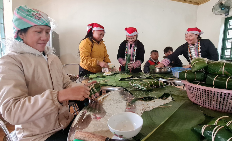 Tạm gác lại những bộn bề lo âu của cuộc sống, người dân xã Liên Minh quây quần gói bánh chưng chuẩn bị đón Tết Nguyên đán Giáp Thìn. (Ảnh: Hương Thu/TTXVN)