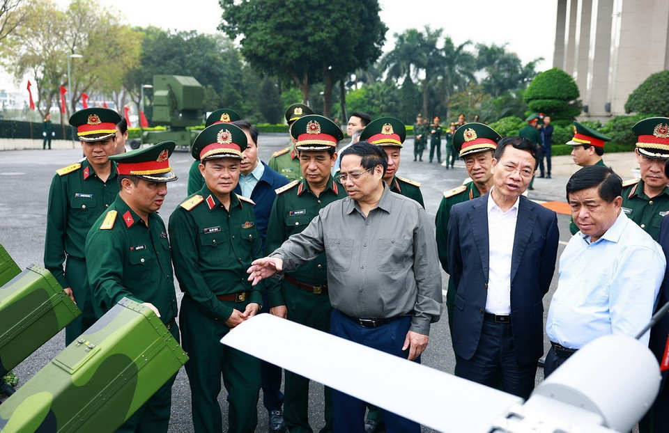 Thủ tướng Phạm Minh Chính trao đổi về sản phẩm công nghệ cao của Tập đoàn Viettel. (Ảnh: Dương Giang/TTXVN)