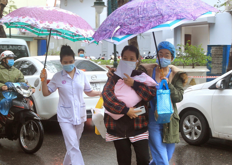 Các y bác sỹ giúp bệnh nhân xuất viện ngày sau khi được gỡ bỏ phong tỏa. (Ảnh: An Đăng/TTXVN)